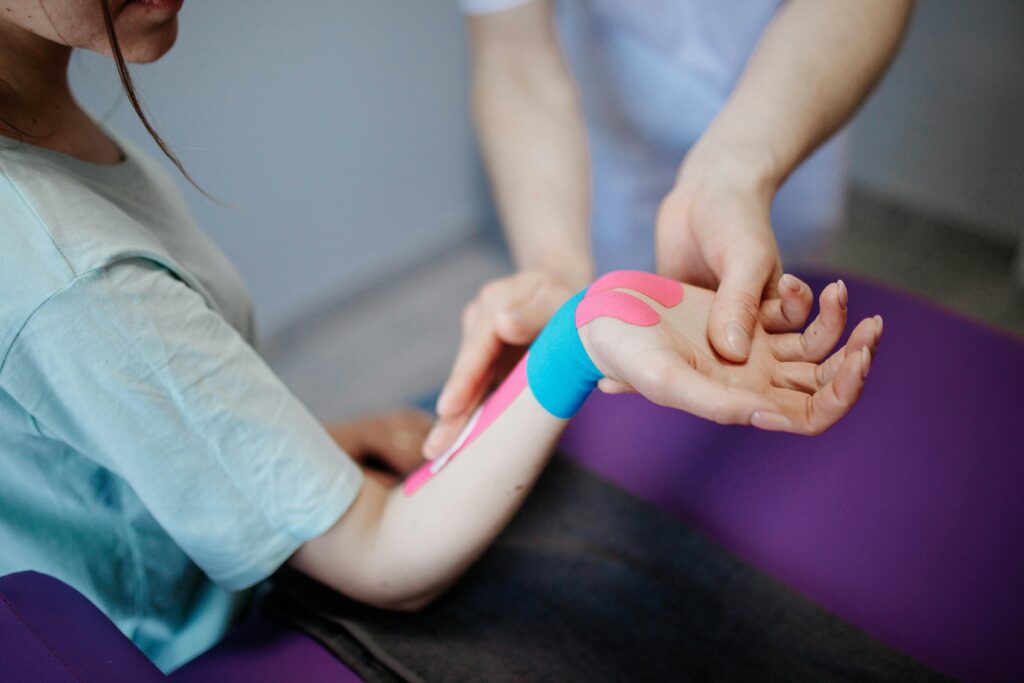 Physiotherapeut taped Handgelenk von Patientin